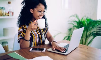 woman drinking coffe in front of laptop