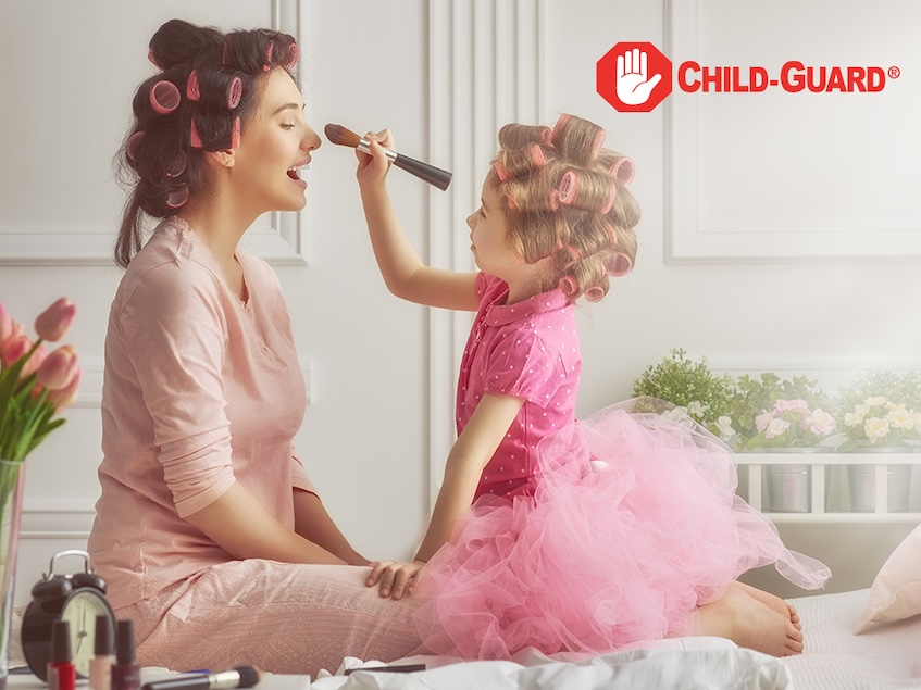 a little girl putting makeup on a woman