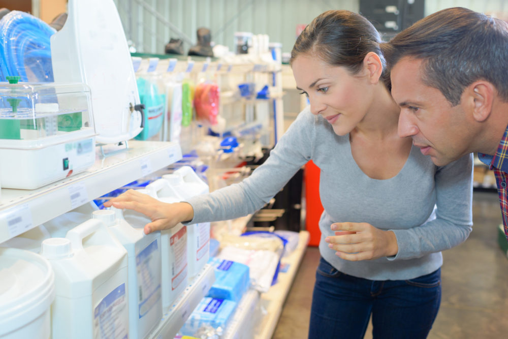 shoppers at the pool store looking at pool chemical packaging